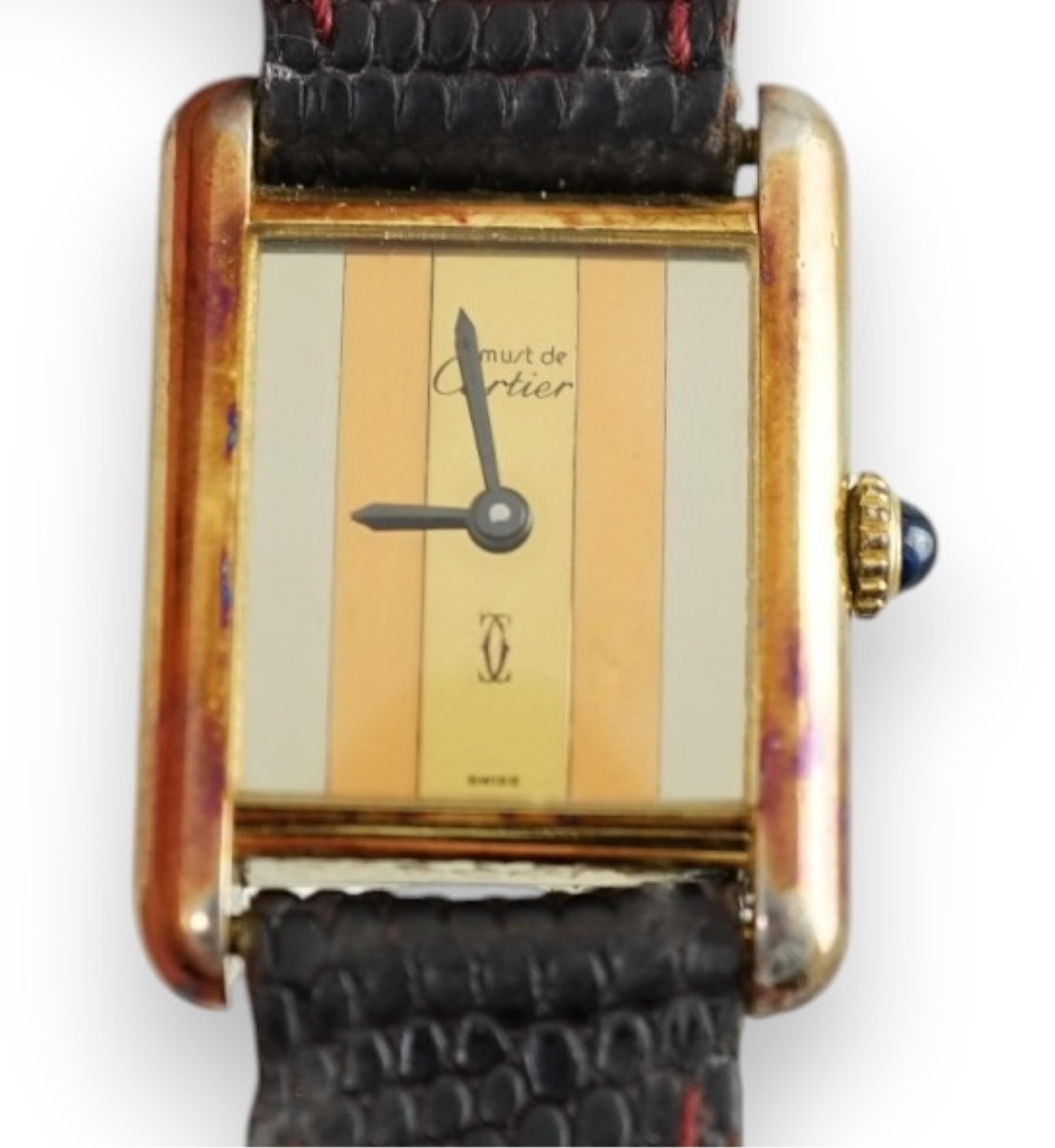 A lady's silver gilt Must De Cartier rectangular dial manual wind wrist watch, case diameter 20mm, on a leather strap.